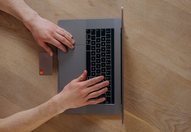 a credit card next to a laptop for an online payment